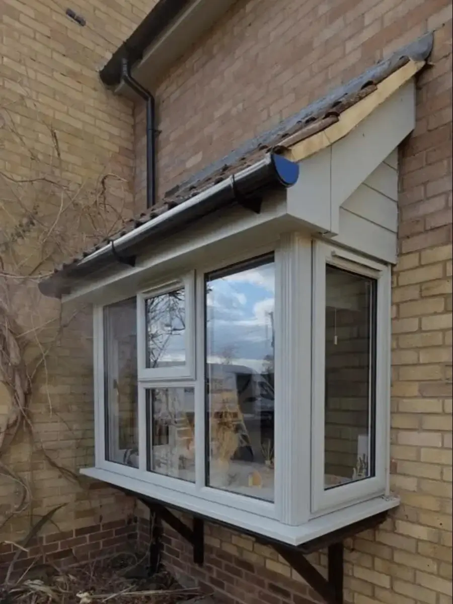 White uPVC projecting bay window with an opening casement beneath a tiled canopy. Installed by Norfolk Exterior Solutions.
